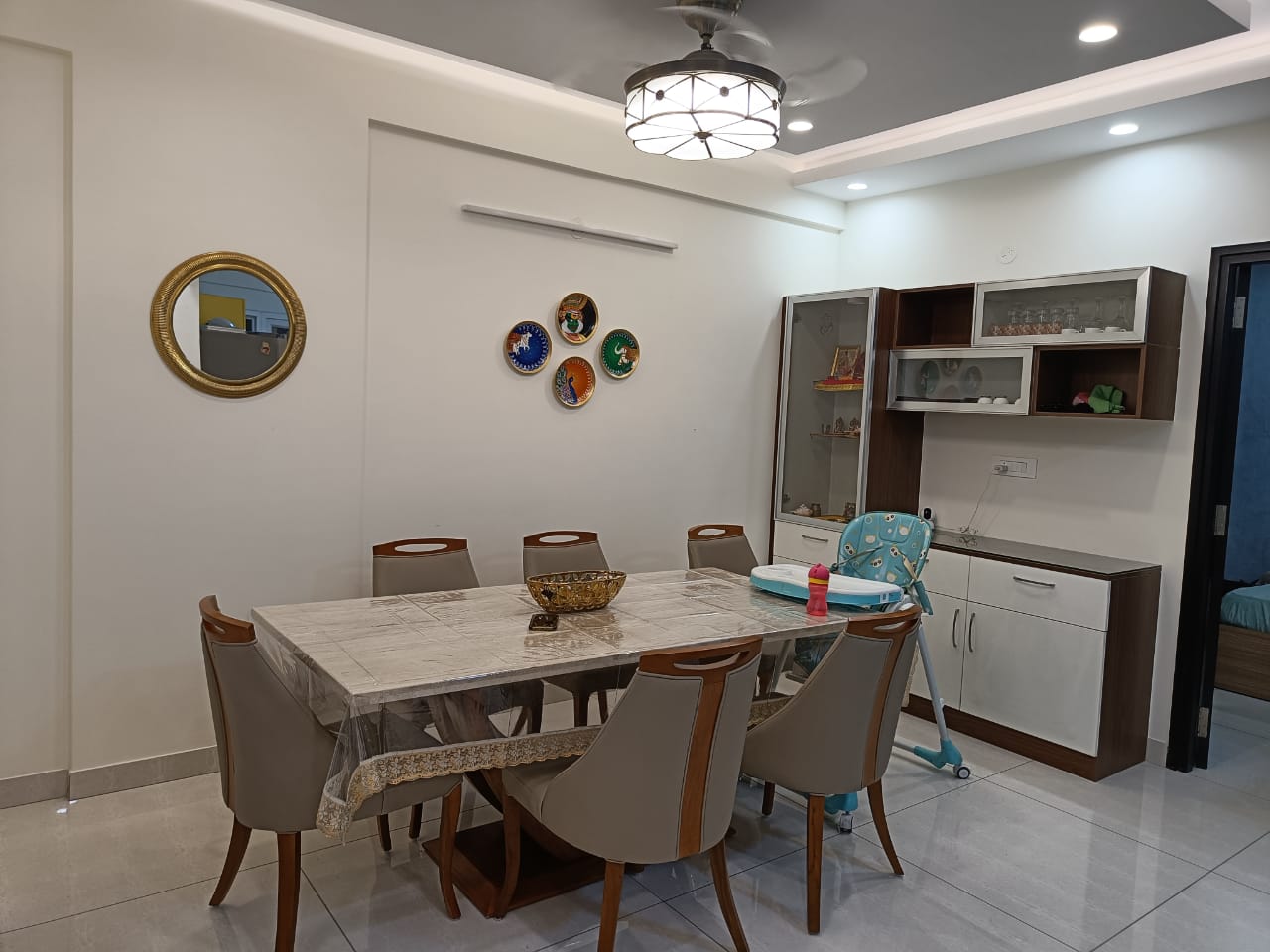 A modern dining room interior designed for comfortable family living with clean aesthetics and practical space planning. This dining area features elegant seating, soft lighting, minimal wall décor, and functional storage units that create a warm and organized atmosphere. The neutral color palette and contemporary furniture design enhance the spacious feel while making the dining space ideal for everyday meals and family gatherings in modern Coimbatore homes. Visit site: https://wallandallinteriors.com/interior-designers-decorators/ #DiningRoomInteriors #InteriorDesignersInCoimbatore #ModernDiningRoom #HomeInteriorsCoimbatore #DiningSpaceDesign #ModernHomeInteriors #ContemporaryInteriors #WallAndAllInteriors #LuxuryInteriors #DiningRoomDesign